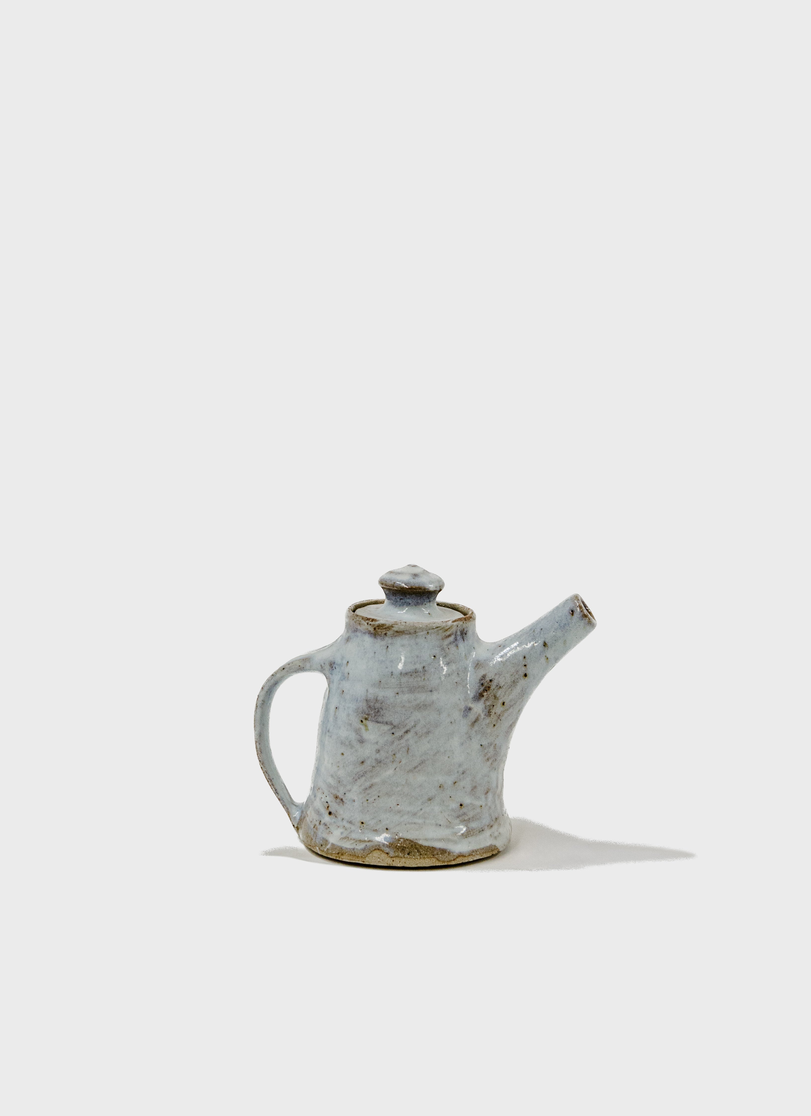 Tall teapot in stoneware clay and porcelain slip decorated with a Nuka style glaze. Handmade in Sydney by Remy Pajaczkowski-Russell.