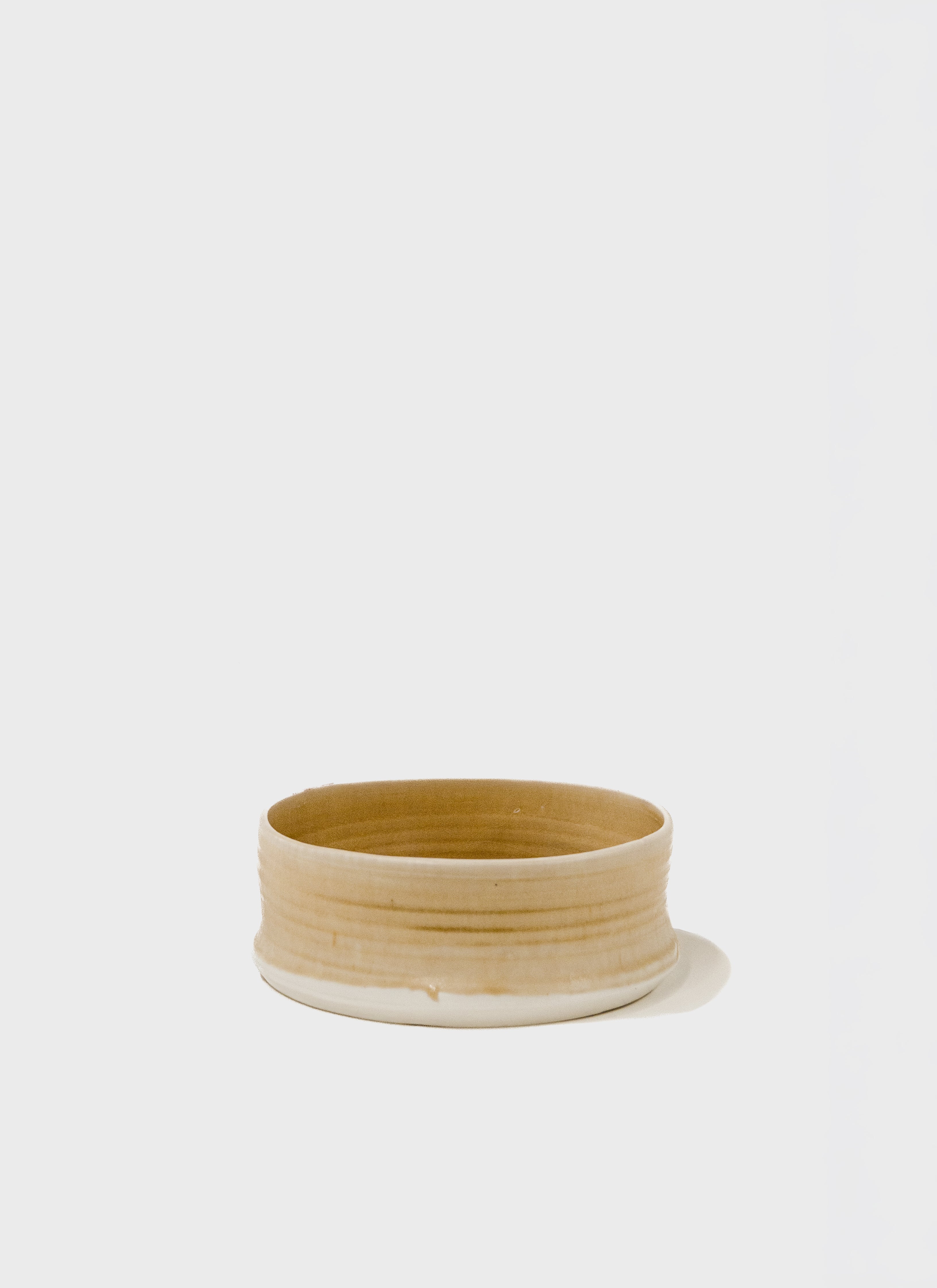 Round cylindrical low bowl with light yellow glaze