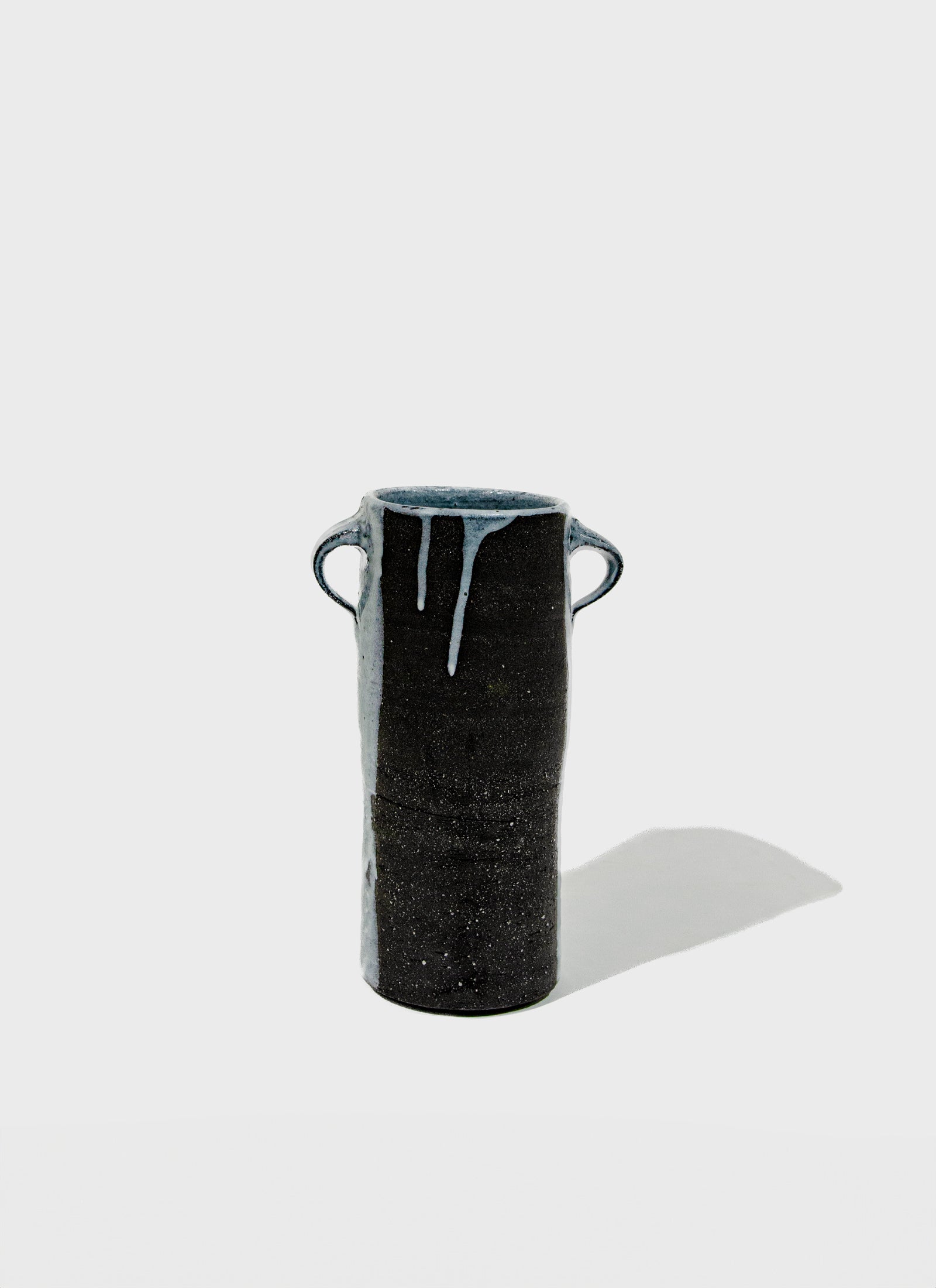 Black ceramic vase with handles on a white background